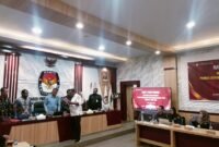 Ketua KPU Fakfak Hendra J.C Talla menyerahkan salinan Keputusan KPU Nomor 3 Tahun 2026 tentang Penetapan Rekapitulasi Data Pemilih Berkelanjutan Kabupaten Fakfak kepada salah satu unsur pimpinan Bawaslu Kabupaten Fakfak.
